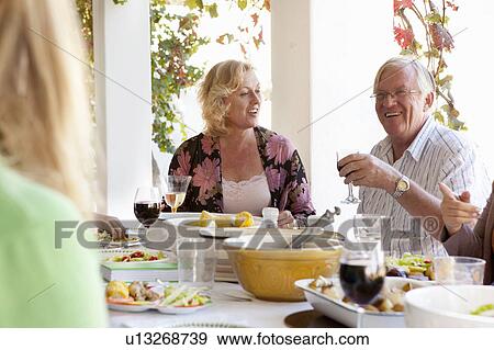 Family eating at table outdoors View Large Photo Image Stock Photo - Family eating at table outdoors. Fotosearch