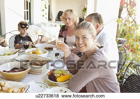 Family eating at table outdoors View Large Photo Image Stock Photo - Family eating at table outdoors. Fotosearch