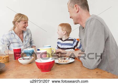 Family laughing at breakfast View Large Photo Image Stock Photo - Family laughing at breakfast. Fotosearch