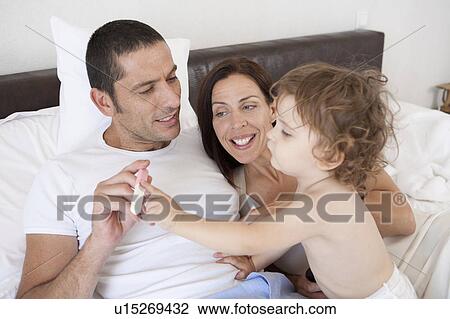 Family playing in bed together View Large Photo Image Stock Image - Family playing in bed together. Fotosearch