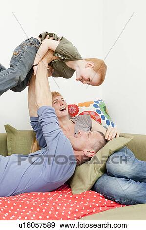 Stock Photo - Family playing together on sofa. Fotosearch