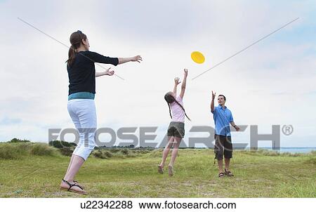 Stock Photo - Family playing with frisbee outdoors. Fotosearch