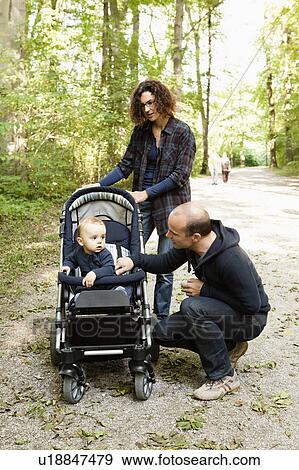Family pushing baby in stroller View Large Photo Image Stock Photo - Family pushing baby in stroller. Fotosearch