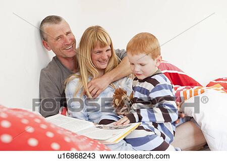 Family reading in bed together View Large Photo Image Stock Image - Family reading in bed together. Fotosearch