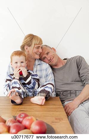 Family relaxing at table together View Large Photo Image Stock Photo - Family relaxing at table together. Fotosearch
