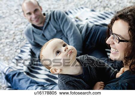 Stock Photography - Family relaxing outdoors together. Fotosearch