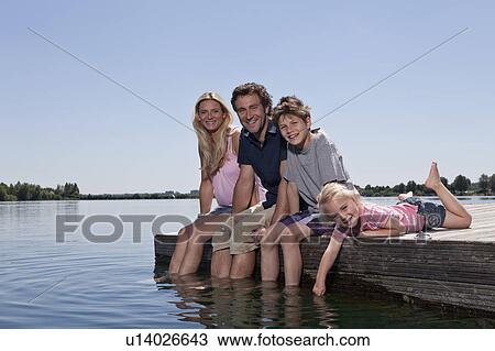 Family relaxing together on dock View Large Photo Image Stock Image - Family relaxing together on dock. Fotosearch