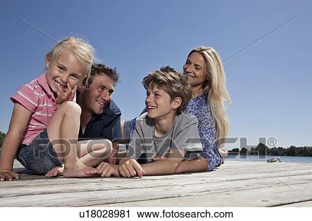 Family relaxing together on dock View Large Photo Image Stock Image - Family relaxing together on dock. Fotosearch