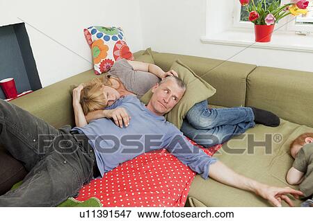 Family relaxing together on sofa View Large Photo Image Stock Photo - Family relaxing together on sofa. Fotosearch