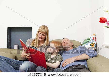 Family relaxing together on sofa View Large Photo Image Stock Photograph - Family relaxing together on sofa. Fotosearch