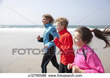 Family running on beach View Large Photo Image Stock Photo - Family running on beach. Fotosearch