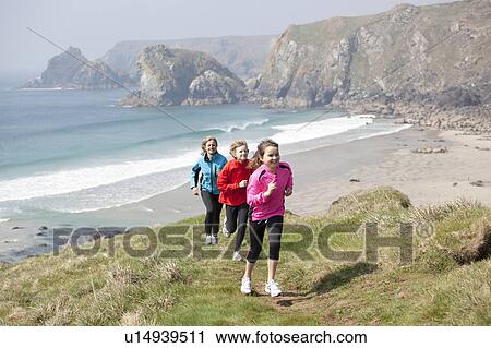 Family running on cliffs over beach View Large Photo Image Stock Image - Family running on cliffs over beach. Fotosearch