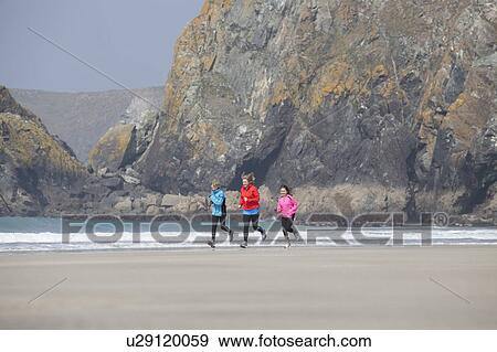 Family running together on beach View Large Photo Image Stock Photo - Family running together on beach. Fotosearch