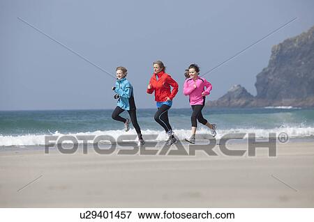 Family running together on beach View Large Photo Image Stock Photo - Family running together on beach. Fotosearch
