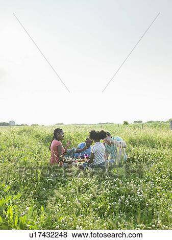 Stock Photo - Family sitting in field of flowers. Fotosearch
