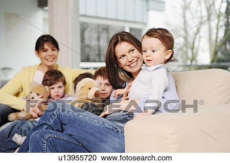 Family sitting on sofa together View Large Photo Image Stock Image - Family sitting on sofa together. Fotosearch