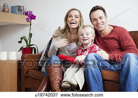 Family sitting on sofa together View Large Photo Image Stock Photo - Family sitting on sofa together. Fotosearch