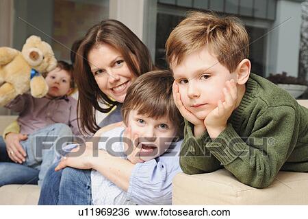 Stock Photograph - Family sitting on sofa together. Fotosearch