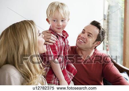 Family sitting on sofa together View Large Photo Image Stock Photography - Family sitting on sofa together. Fotosearch