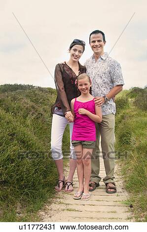 Stock Image - Family standing on beach walkway. Fotosearch