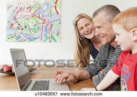 Stock Photo - Family using laptop together. Fotosearch