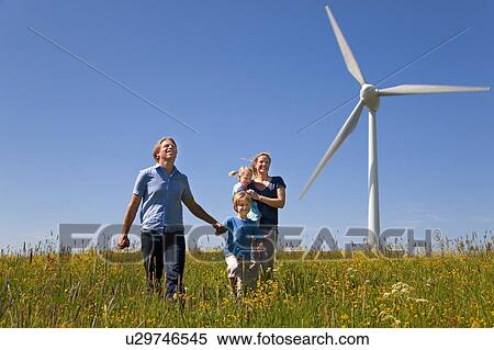 Family walking in field by wind turbine View Large Photo Image Stock Photography - Family walking in field by wind turbine. Fotosearch