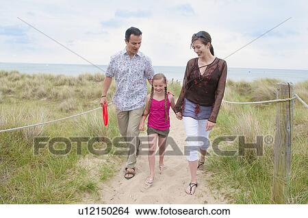 Picture - Family walking together on beach. Fotosearch
