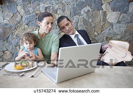 Picture - Family working at breakfast table. Fotosearch