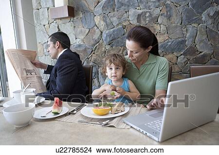 Picture - Family working at breakfast table. Fotosearch
