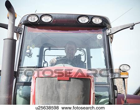 Stock Photo - Farmer driving tractor on farm. Fotosearch
