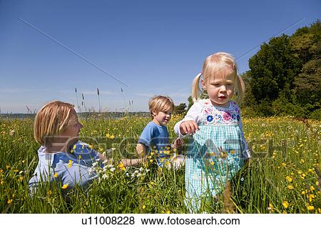 Stock Photo - Father and children in field of flowers. Fotosearch