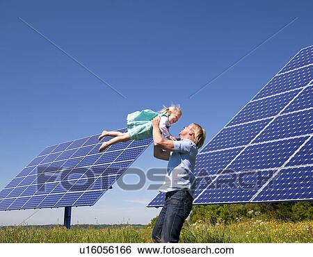 Stock Photograph - Father and daughter by solar panels. Fotosearch