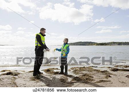 Stock Photograph - Father and son cleaning beach. Fotosearch