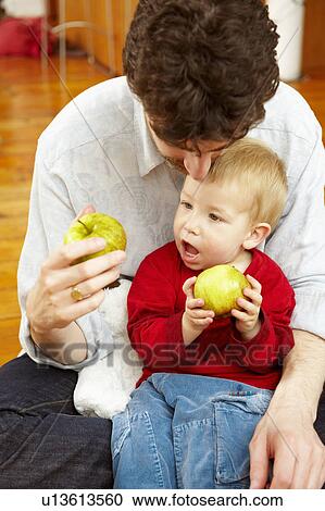 Father and son eating apples together View Large Photo Image Stock Image - Father and son eating apples together. Fotosearch