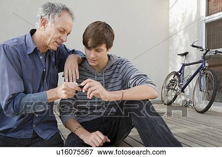 Father and son examining tool together View Large Photo Image Stock Photo - Father and son examining tool together. Fotosearch