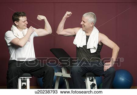 Father and son flexing muscles in gym View Large Photo Image Stock Image - Father and son flexing muscles in gym. Fotosearch