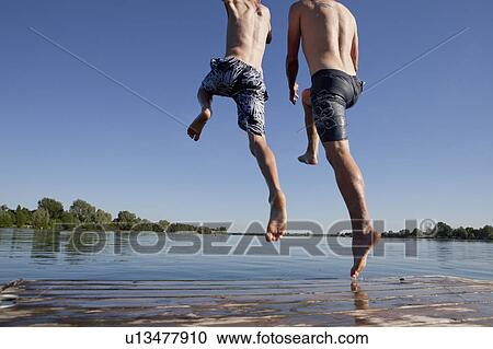 Father and son jumping into lake View Large Photo Image Stock Image - Father and son jumping into lake. Fotosearch