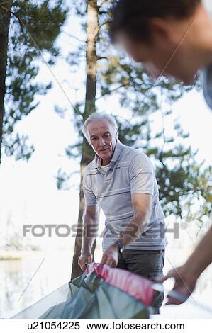 Father and son pitching a tent together View Large Photo Image Stock Photography - Father and son pitching a tent together. Fotosearch
