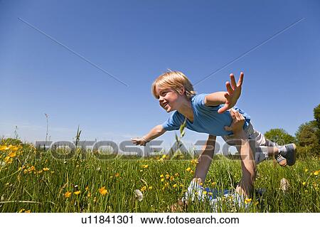 Father and son playing airplane in field View Large Photo Image Stock Image - Father and son playing airplane in field. Fotosearch