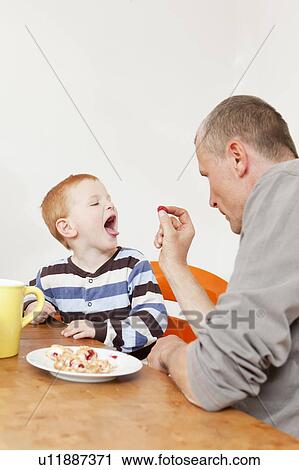 Father and son playing at table View Large Photo Image Stock Image - Father and son playing at table. Fotosearch