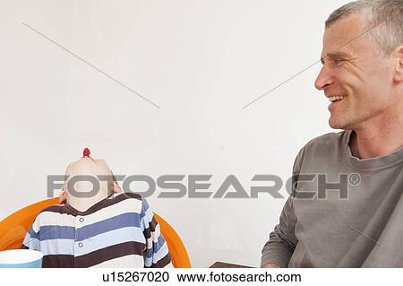 Stock Image - Father and son playing at table. Fotosearch
