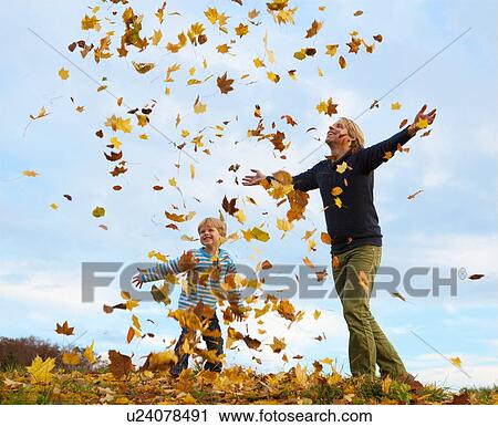 Father and son playing in autumn leaves View Large Photo Image Stock Image - Father and son playing in autumn leaves. Fotosearch