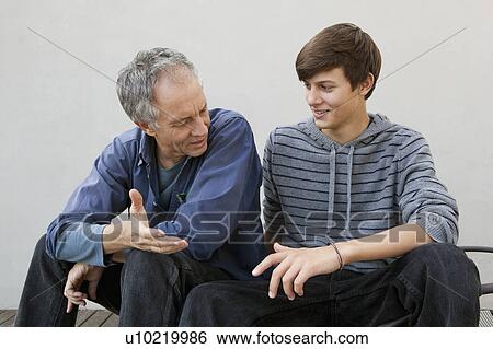 Father and son sitting together View Large Photo Image Stock Photograph - Father and son sitting together. Fotosearch