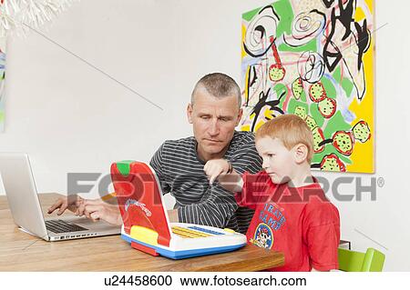 Father and son working on laptops View Large Photo Image Stock Image - Father and son working on laptops. Fotosearch