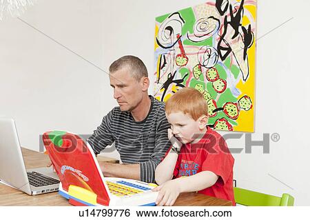 Father and son working on laptops View Large Photo Image Stock Photograph - Father and son working on laptops. Fotosearch