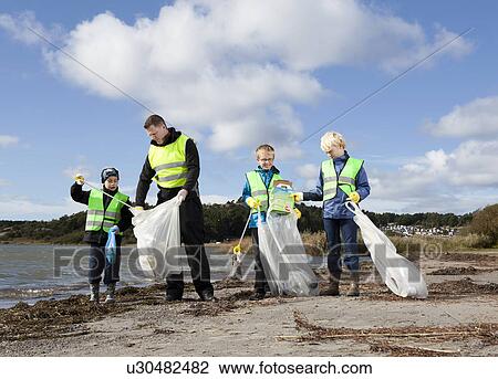 Father and sons cleaning beach View Large Photo Image Stock Image - Father and sons cleaning beach. Fotosearch
