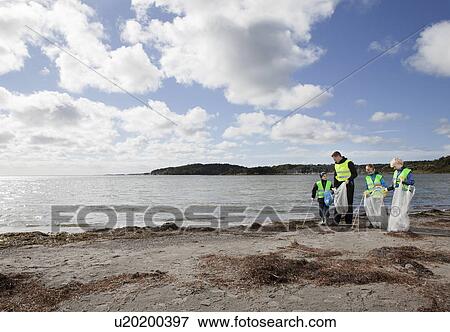 Stock Photo - Father and sons cleaning beach. Fotosearch