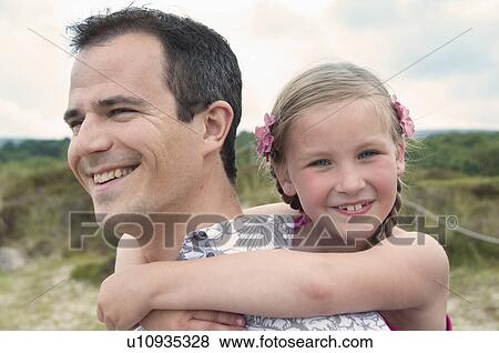 Father carrying daughter piggy back View Large Photo Image Stock Photo - Father carrying daughter piggy back. Fotosearch