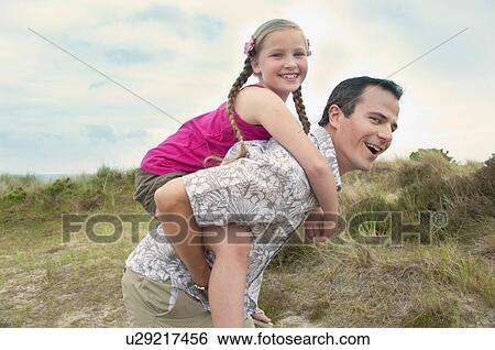 Father carrying daughter piggy back View Large Photo Image Stock Photograph - Father carrying daughter piggy back. Fotosearch