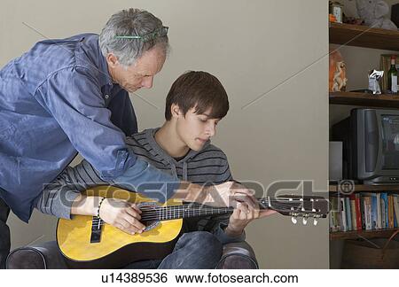 Father helping son play guitar View Large Photo Image Stock Photograph - Father helping son play guitar. Fotosearch
